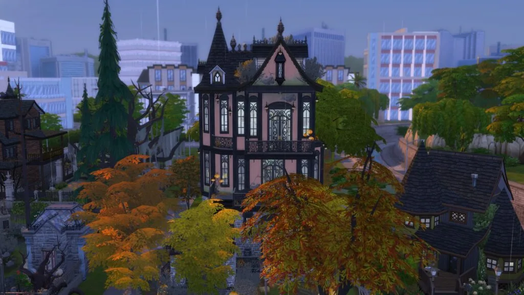 Pink and black Gothic Victorian home surrounded by autumn foliage.